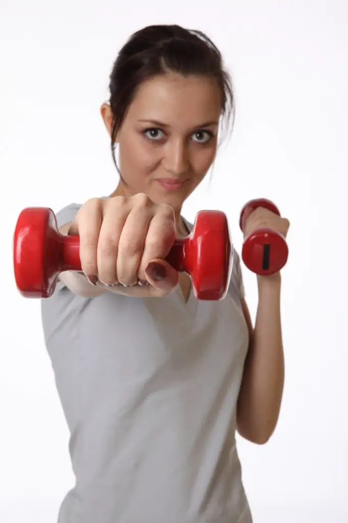 MEDICINA ONLINE DONNA CHE SI ALLENA COI PESI MUSCOLI PALESTRA.