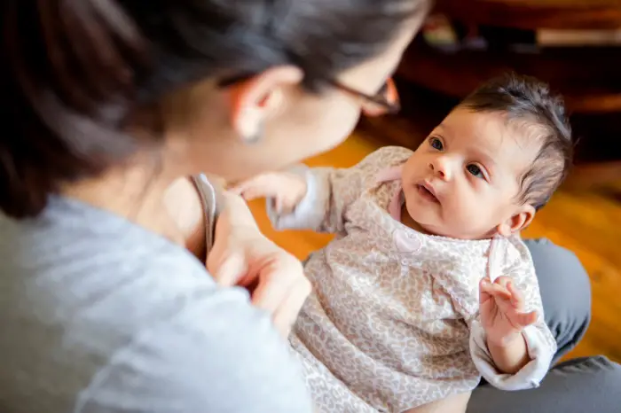 Mother interacting with baby girl at home.